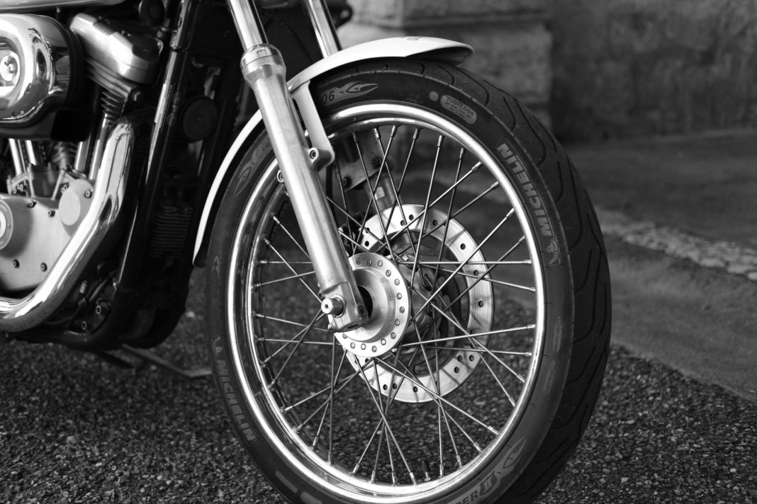 Pengendara memeriksa kondisi ban motor menjelang musim hujan