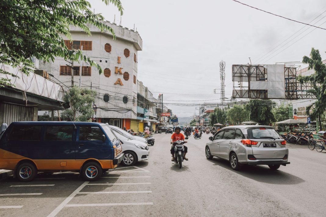 Pengendara motor melintasi jalan berdebu di Nusa Tenggara Timur